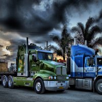 two trucks parked under stormy clouds hdr