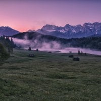 cabins on the meadow with fog off the lake