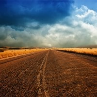 dirt road under stormy clouds