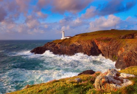 beautiful lighthouse over a rugged seashore - clouds, shore, lighthouse, cliff, rugged, sea