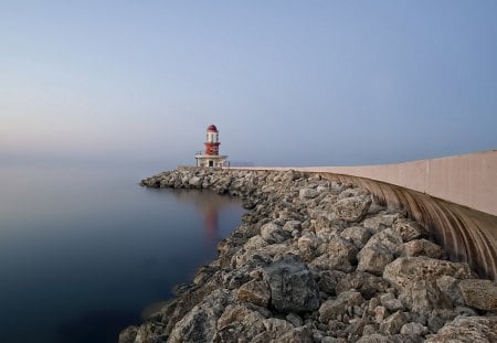 lighthouse on a rock pier at a misty sea - lighthouse, pier, sea, mist, rocks