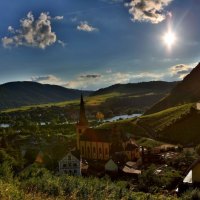 bright sun on a church in a river valley town