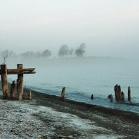 broken old pier on a foggy beach