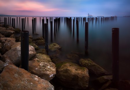 metal post in a bay shoreline - ships, shore, sunset, pipes, bay, rocks