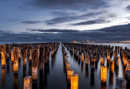 rows and rows of wooden pylons - sundown, clouds, rows, bay, pylons