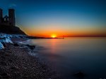 cathedral ruins on seashore at sunset