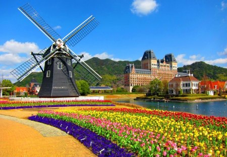 A windmill - nice, sky, water, colorful, wind, spring, calm, pretty, reflection, river, lake, travel, shore, summer, lovely, mill, nature, village, town, beautiful, windmill, flowers