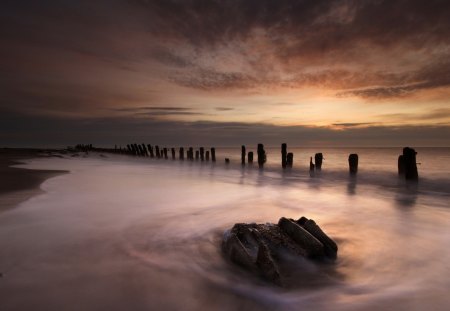 wooden stakes along a beautiful beach - beach, clouds, twilight, sea, stakes, mist