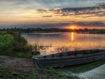 old boat in lake under beautiful sunset