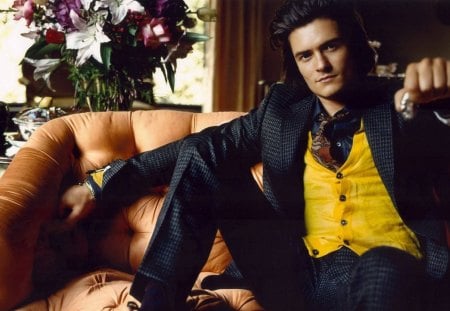 Orlando Bloom - actor, vest, yellow, sofa, flower, interior, man, bouquet, suit, black, orlando bloom, movie