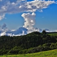 clouds over forest covered mountains