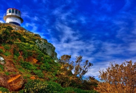 lighthouse on a hill under blue sky - sky, lighthouse, hill, rocks, bushes