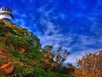 lighthouse on a hill under blue sky