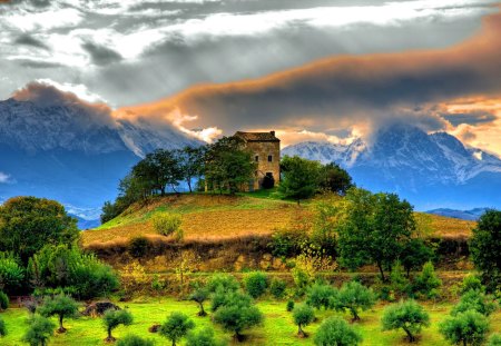 Between mountains - nice, sky, trees, greenery, mountains, rocks, amazing, mountainscape, clouds, castle, green, house, hill, summer, slopes, peaks, lovely, nature, beautiful