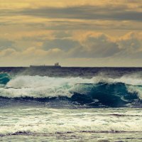 ship along the horizon behind sea waves