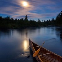 canoe on a river in moonlight