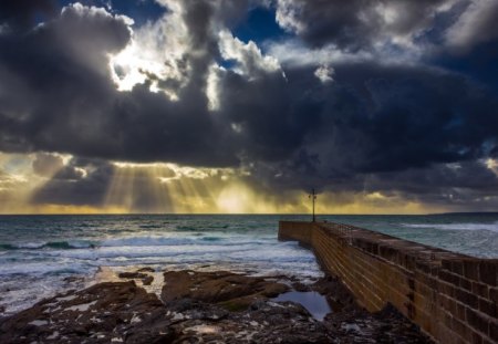 pier into a sea under sun rays - pier, bricks, clouds, sunset, sea, sun rays