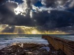 pier into a sea under sun rays