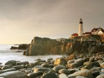 lighthouse on rough rocky shore in portland maine