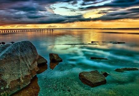 colorful rocky beach at sunset - clouds, birds, sunset, beach, pylons, colors, rocks