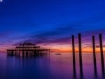 ruins of brighton pier under a moon