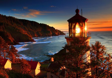 Lighthouse at sunset - nice, sky, beach, sundown, water, sunset, bay, coast, rocks, view, pretty, cliffs, ocean, houses, lighthouse, mountain, hills, light, vilalge, summer, shore, lovely, waves, nature, beautiful, stones, sea