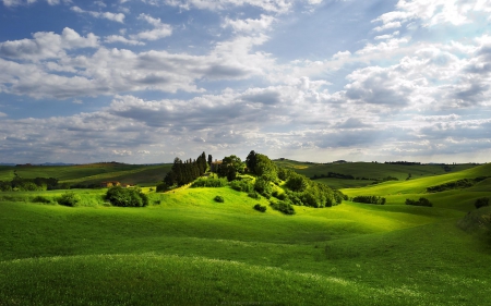 beautiful tuscan landscape - clouds, hills, grass, farms