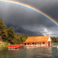 rainbow over a boat house on a river