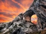 sunset behind a portal in a rocky cliff