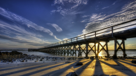 sunrise behind a beautiful pier - shadows, beach, pier, sea, sunrise