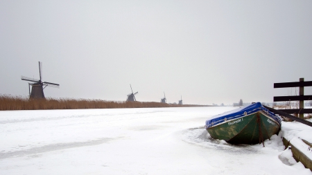 row of windmills along a wintry channel - windmills, winter, channel, boat