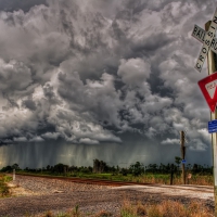 railroad crossing under stormy skies hdr