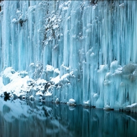 icicles down a cliff into a pond