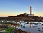 mighty lighthouse on rocky hill reflected