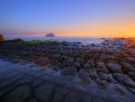 fantastic rock formation in seashore at sunset