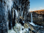 waterfall and icicles on formation cliff