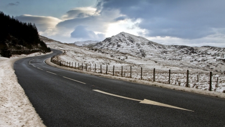 blacktop highway coming down a mountain in winter - clouds, highway, winter, blacktop, mountains, fence