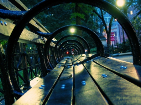 LOOKING THROUGH A CITY BENCH - lights, landscape, night time, blue, bench, cityscapes, city, on the streets, twilight