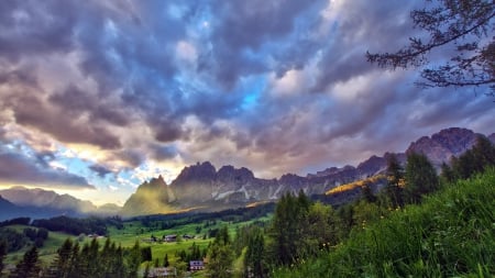 magnificent summer alpine landscape - meadows, forest, mountains, clouds, village