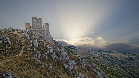 sun rays illuminating mountaintop castle ruins - ruins, clouds, castle, mountains, sun rays, rocks