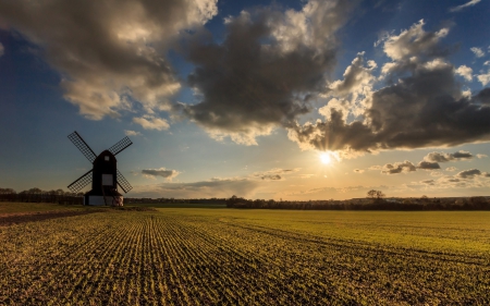 windmill surrounded by cultivated fields - fields, windmill, clouds, sun