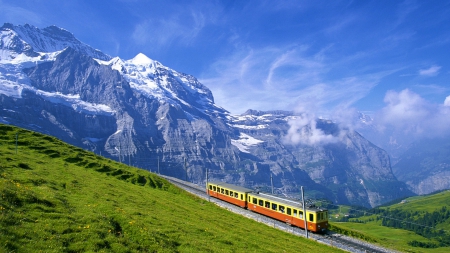 lovely train high up in the alps - clouds, train, tracks, grass, meadow, mountains