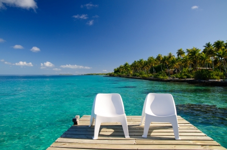 Chairs on Decking overlooking clear blue lagoon and beach at Fakarava Island, French Polynesia - warm, lagoon, blue, beach, chairs, island, french, polynesia, sand, holiday, two, paradise, escape, sun, lush, trees, beautiful, sea, table, ocean, palm, chair, islands, tropical, fakarava, decking