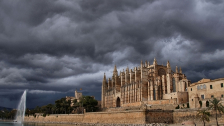 beautiful cathedral in majorca spain - fountain, river, clouds, palms, cathedral