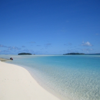 white sand beach and clear blue lagoon - The Cook Islands Polynesia