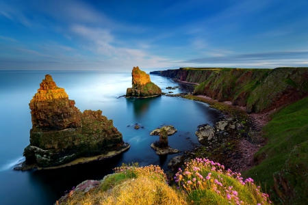 Sea rocks lit by the sun - calm, quiet, coast, landscape, crystal, flowers, shore, view, lake, nice, sky, sun, water, beautiful, mirrored, sea, lovely, peaks, stones, nature, clear, rocks