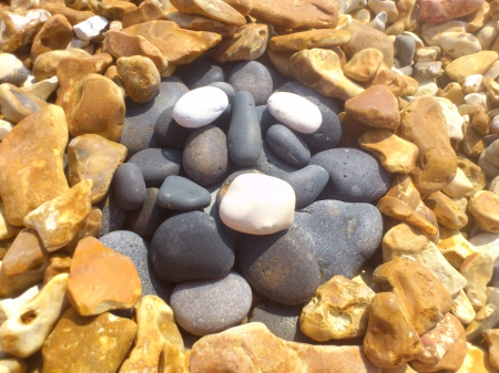 pebbles - beach, sun, funny, bright, face, aztec, pebbles, sunny, strange