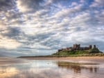 magnificent old castle on a hill above a beach hdr