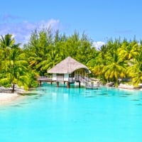 Clear aqua blue lagoon and white sand beach on paradise island Bora Bora