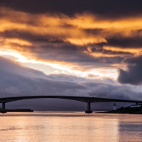 skye bridge in scotland under fiery sky